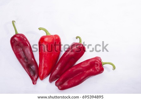Four red peppers as a vegetable on white background