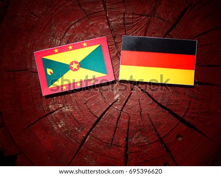 Grenada flag with German flag on a tree stump isolated