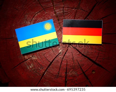 Rwanda flag with German flag on a tree stump isolated