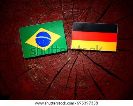 Brazilian flag with German flag on a tree stump isolated