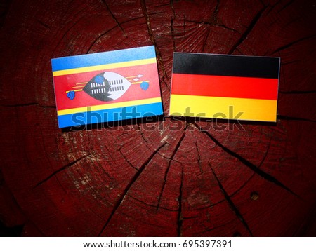 Swaziland flag with German flag on a tree stump isolated