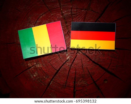 Malian flag with German flag on a tree stump isolated