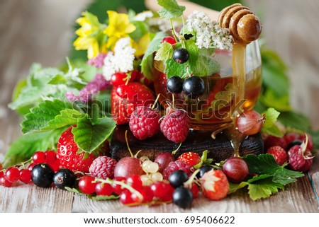 Hot herbal tea with milfoil, honey and fresh summer berries on rustic background