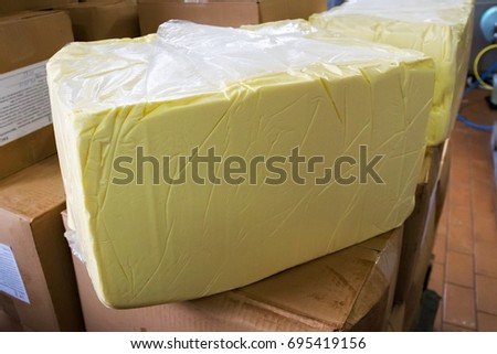 Large piece of butter in the storage at the dairy plant. Royalty-Free Stock Photo #695419156