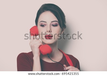 Portrait of young housewife with red handset on white background
