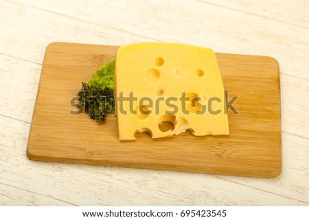 Piece of cheese over the wooden plate
