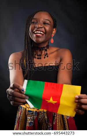 Young beautiful African fashion model with flag of Cameroon in traditional dress.