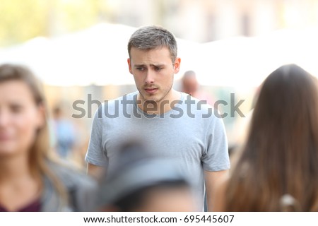 Front view portrait of a sad boy walking on the street Royalty-Free Stock Photo #695445607