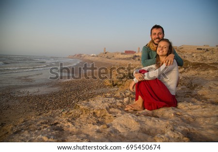 
Traveler couple taking photo on city fortress wall of Essaouira, Morocco, taking selfie at sunset. Travel lifestyle adventure concept. Active vacations.