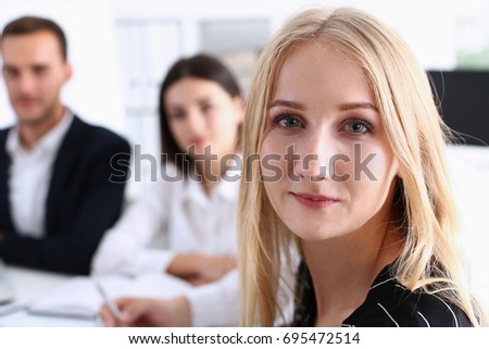 Beautiful smiling cheerful girl at workplace look in camera with colleagues group in background. White collar worker at workspace, job offer, modern lifestyle, client visit, profession train concept