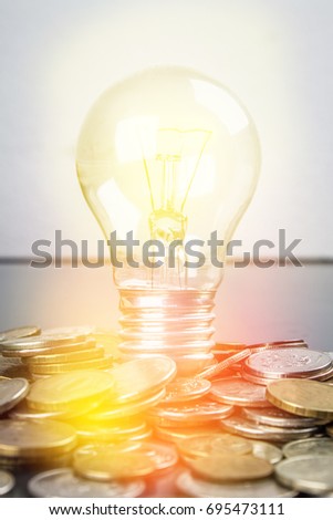 Light Bulb on scattered Russian coins on a gray background with leaves of clover. Good luck, St. Patrick's day