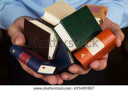 Hands holding a stack of books