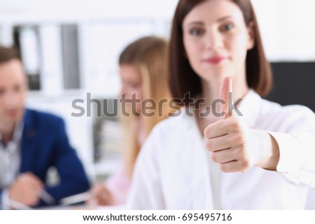 Female arm show OK or approval with thumb up in creative people office closeup. High level quality product, serious offer conference, mediation solution, advisor participation concept