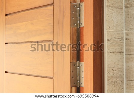 Stainless door hinges on wooden swing door Royalty-Free Stock Photo #695508994
