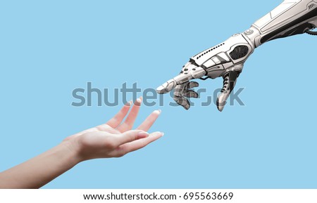 Female human hand and robot's as a symbol of connection between people and artificial intelligence technology isolated on blue for design. Royalty-Free Stock Photo #695563669