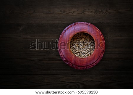 Dill/weed seed in a wooden bowl on a textured background  From Top View 