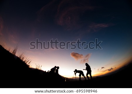 A silhouette of photographer taking picture of their kids.
