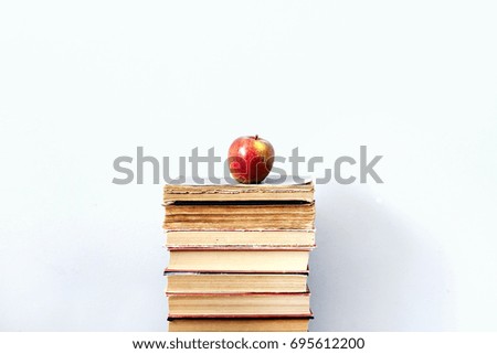 Apple on a stack of books on white background
