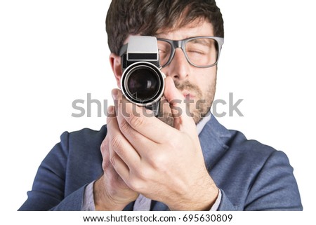 Young crazy businessman with a vintage camera. Recording cinema
