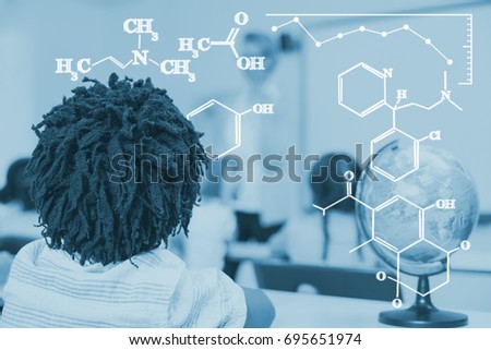 Digital image of chemical formulas against rear view of school boy studying in classroom