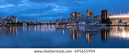 Vancouver, British Columbia - Canada. Downtown iconic landmark on water reflection near Burrard inlet on a chilly night just after a rain. Beautiful British Columbia - Canada.
