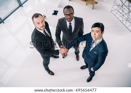 team of multiethic businessmen holding hands
