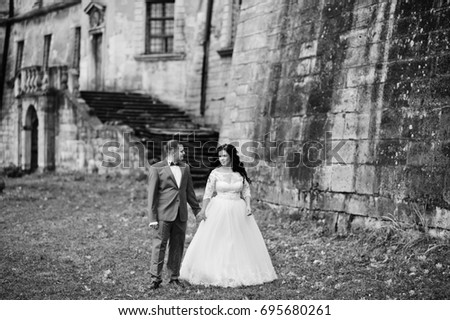 Beautiful wedding couple standing outside with a beautiful architectural background. Black and white photo.