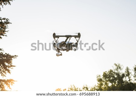 White drone, quadrocopter with photo camera flying