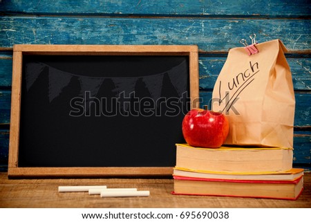 Illustration image of bunting hanging against blank blackboard with packed lunch and books