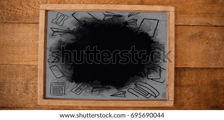 Digital image of school supplies against high angle view of chalkboard