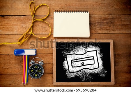 Graphic image of sharpener against overhead view of chalkboard with equipment