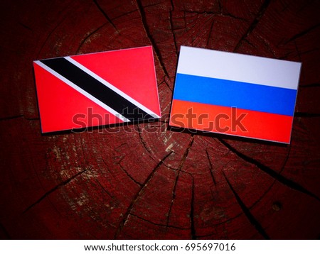 Trinidad and Tobago flag with Russian flag on a tree stump isolated