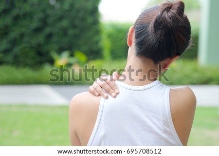 Women have neck pain, shoulder pain, at the park health concept. Royalty-Free Stock Photo #695708512
