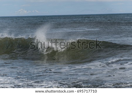 Sea surf on the beach with black volcanic sand in Kamchatka