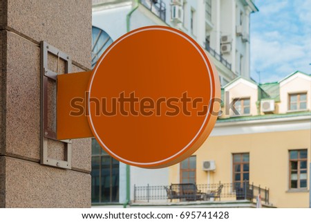 Blank orange round signboard on the granite wall. 