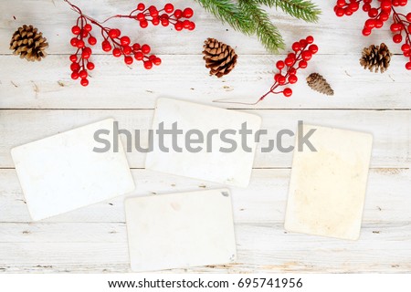 Christmas theme background with blank photo paper and decorating elements on white wood table. Creative Flat layout and top view composition with border and copy space design.