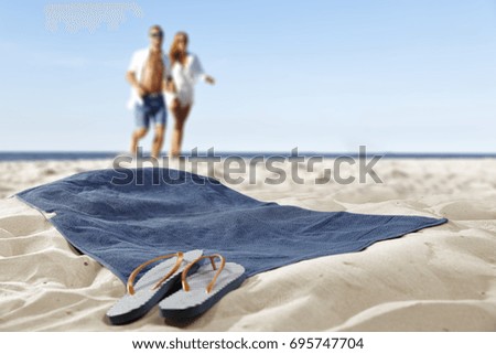 background of free space for your decoration of towel on sand and two lovers 