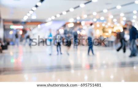 Defocused airport corridor with walking travelers,shopping mall