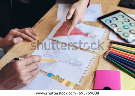 Close up of Two young dressmaker or designer colleagues's hands working as fashion designers and drawing sketches for clothes, profession and job occupation, Fashion Designer Stylish Concept.
