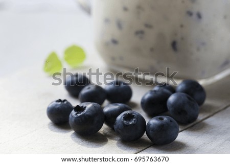 Blueberries and banana smoothie garnished with mint. Smoothie on a kitchen counter. 