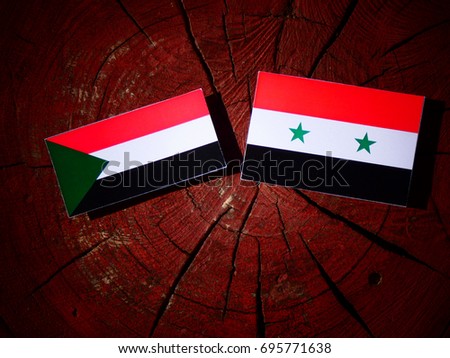 Sudan flag with Syrian flag on a tree stump isolated
