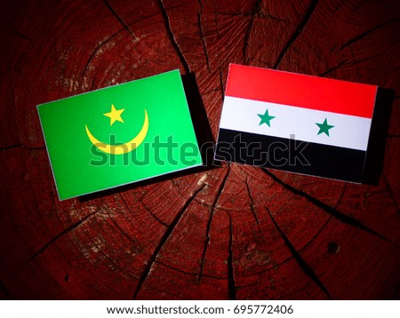 Mauritania flag with Syrian flag on a tree stump isolated