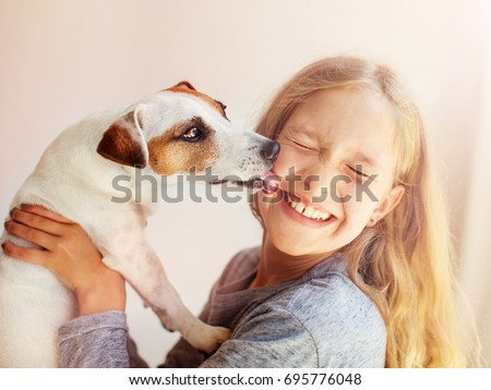 Happy child with dog. Portrait girl with pet. Jack Russell licks a teen Royalty-Free Stock Photo #695776048