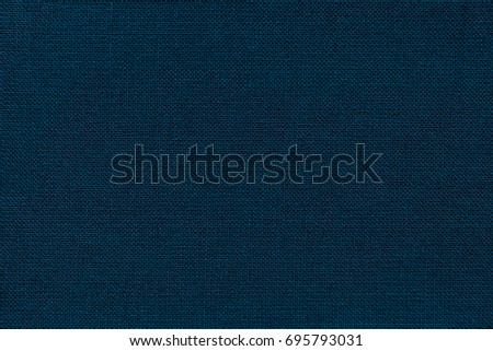 Dark navy blue background from a textile material with wicker pattern, closeup. Structure of the denim fabric with natural texture. Cloth backdrop.