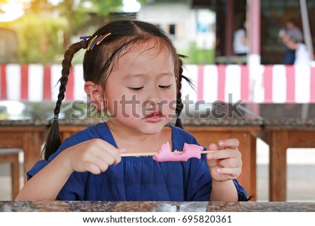 Adorable little Asian girl eating ice-cream