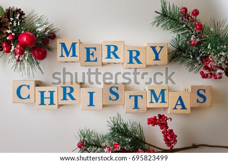 The inscription "Merry Christmas" from wooden cubes and Christmas decorations
