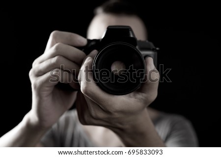closeup of a young caucasian man shooting a photo with a reflex camera