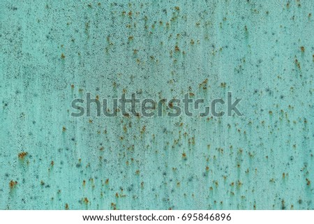 Green cracked painting on rusty metal surface