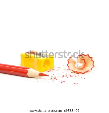 Sharpened pencil next to the sharpener and shavings. Isolated on white background