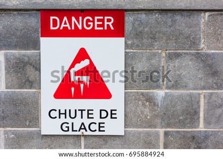 Closeup of danger sign for falling icicles in winter with picture